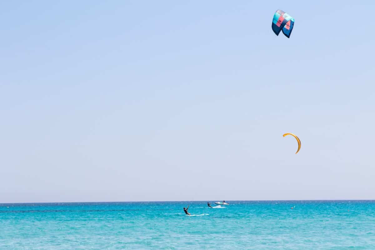 July 23, 2021: boys practicing kitesurfing in the crystal sea near the beach of La Cinta, Sardinia