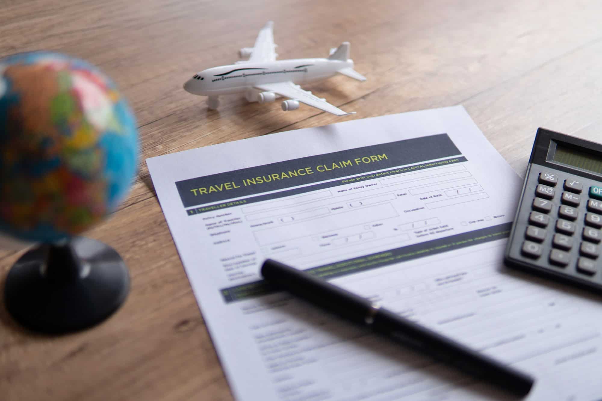 Image avec mise au point sélective d'un formulaire de demande d'assurance voyage sur une table en bois.