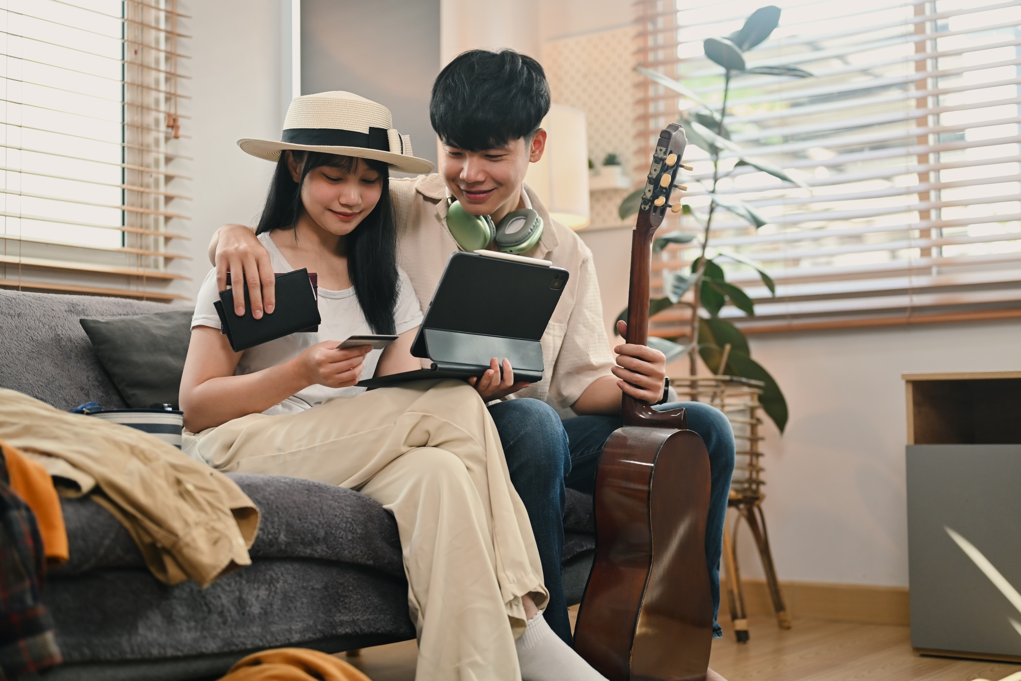Jeune couple heureux préparant un voyage de vacancesacheter un vol ou réserver un hôtel sur une tablette numérique