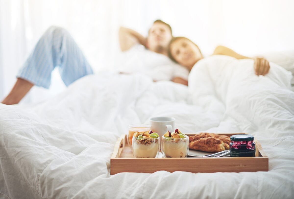 Nothing better than breakfast in bed. Shot of a loving young couple enjoying breakfast in bed.
